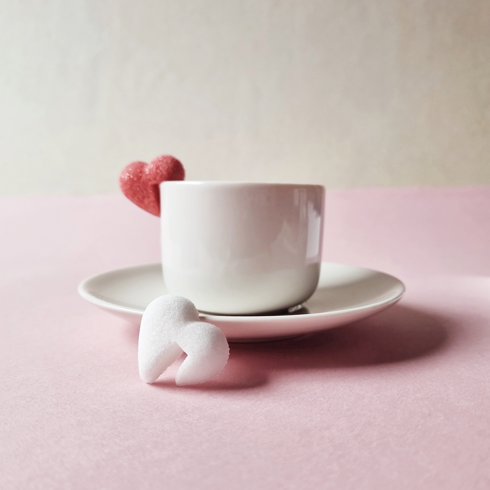 Sucre en forme de coeur, blanc et rouge, accroché sur une tasse